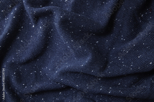 A full page close up of speckled navy blue knit ware sweater fabric texture