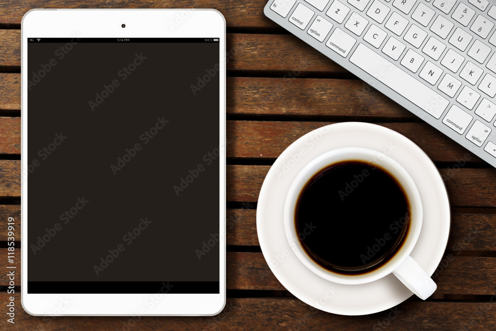 workplace with tablet computer showing magazine cover and a cup