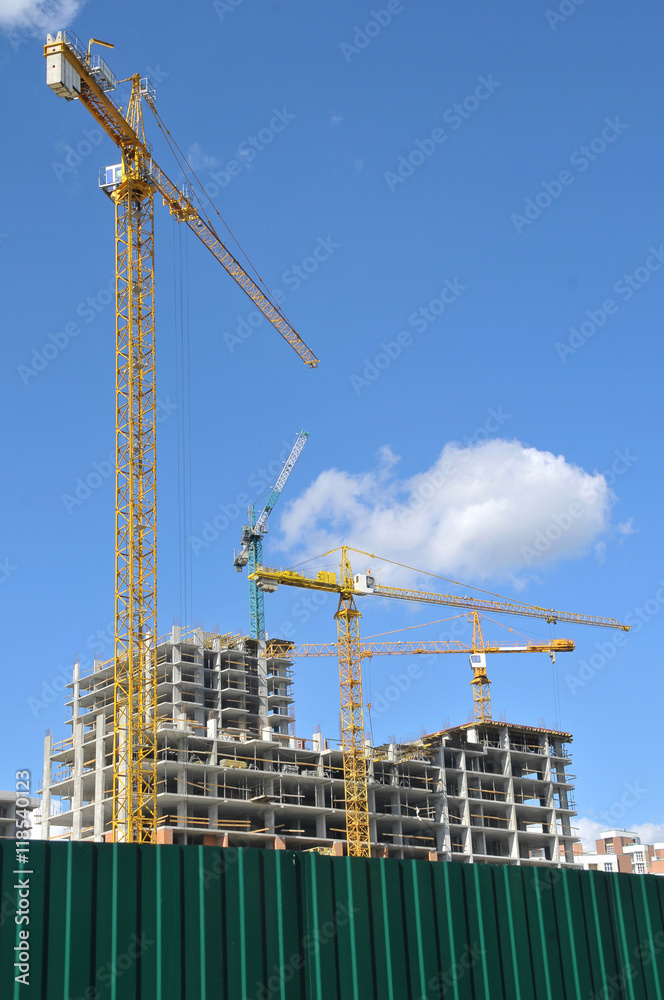 Tower crane working on a construction site, construction of a house, tower crane against the sky, construction machinery building house