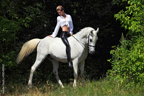 Beautiful model horseback riding in forest 