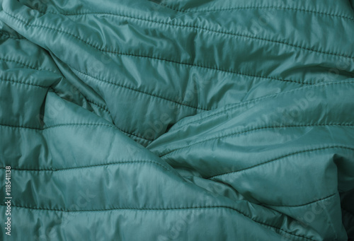 A full page close up of quilted turquoise sleeping bag fabric texture