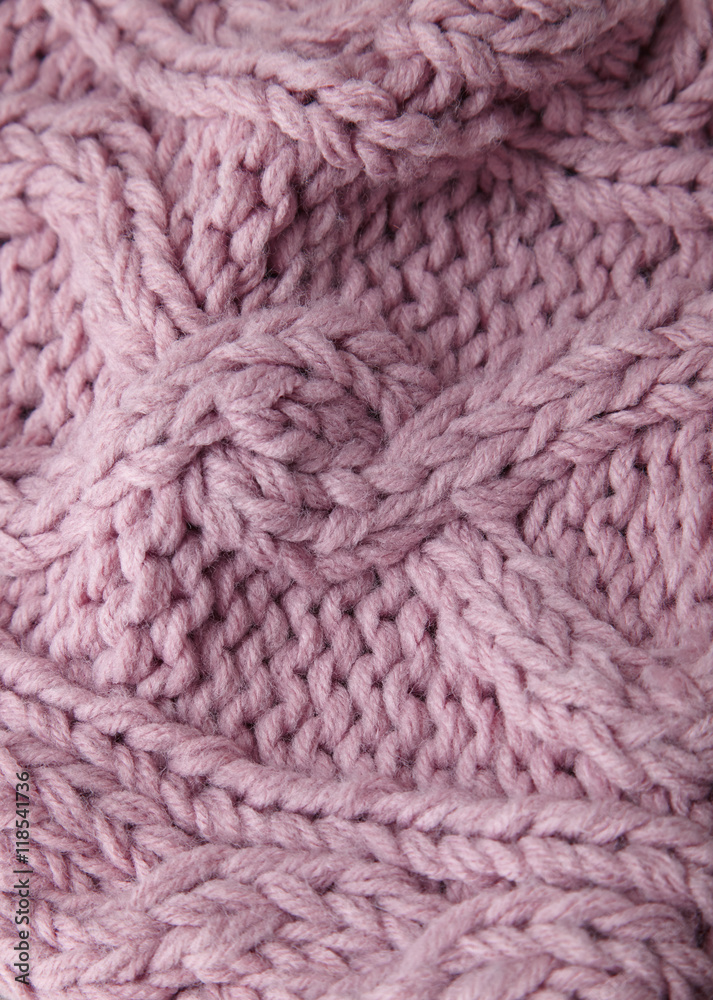 A full page close up of pink cable knit sweater fabric texture