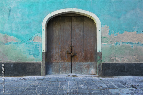 Old door in a cyan wall © lucacasula91