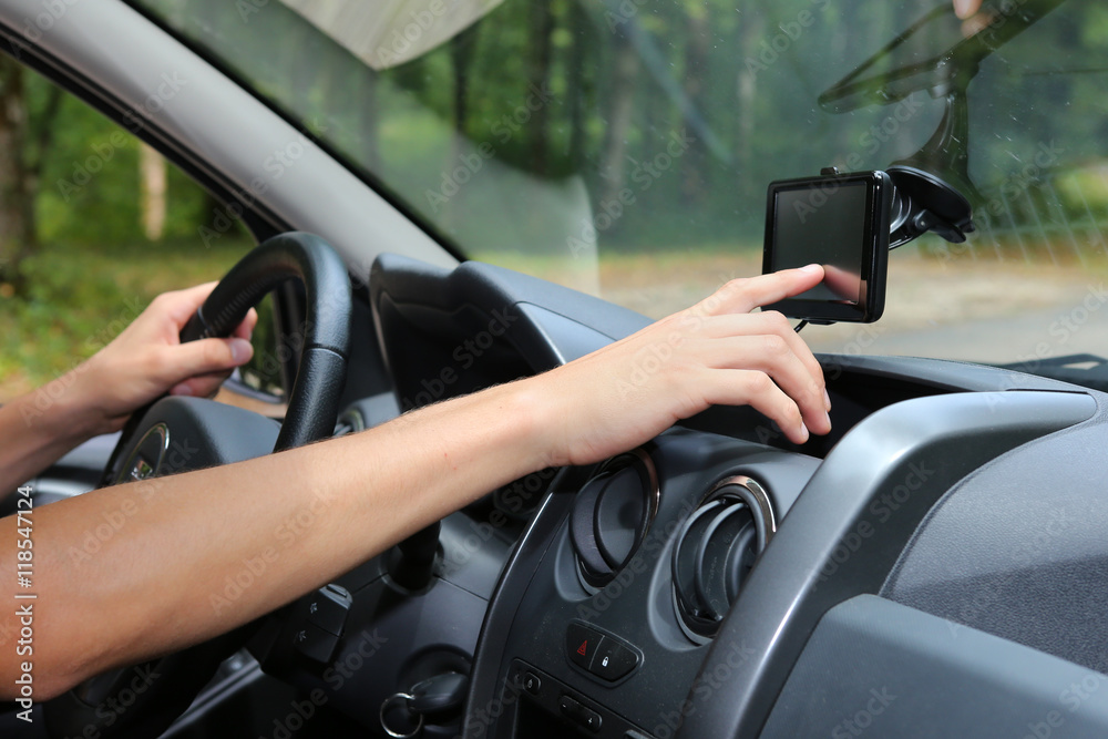Man adjusting his GPS in a car Man adjusting his GPS in a car