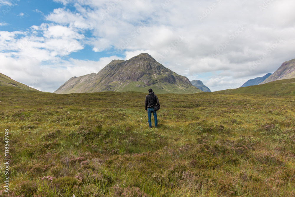 Fototapeta premium Junger Mann blickt in die Landschaft, Highlands, Schottland, Rückenansicht,