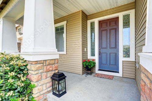 Front entry door with concrete floor porch and flowers pot