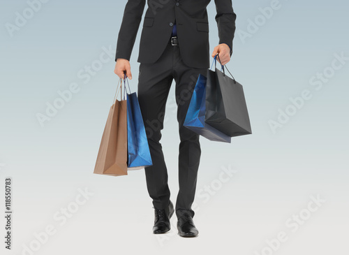 close up of man in suit with shopping bags