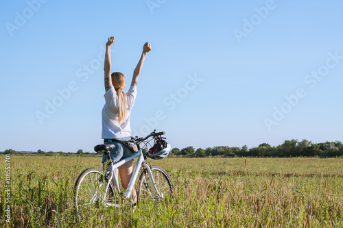 picture of woman with bicycle rising hands 
