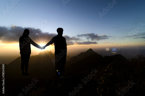 Couple silhouette outdoors, beautiful sunset behind.