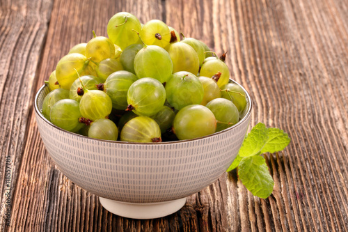 Fresh green gooseberry on old wooden background