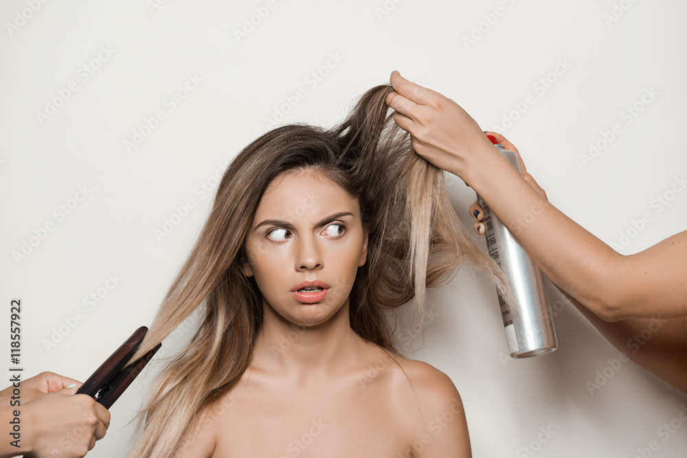 Fototapeta premium Hands doing hairstyle to young beautiful naked girl.
