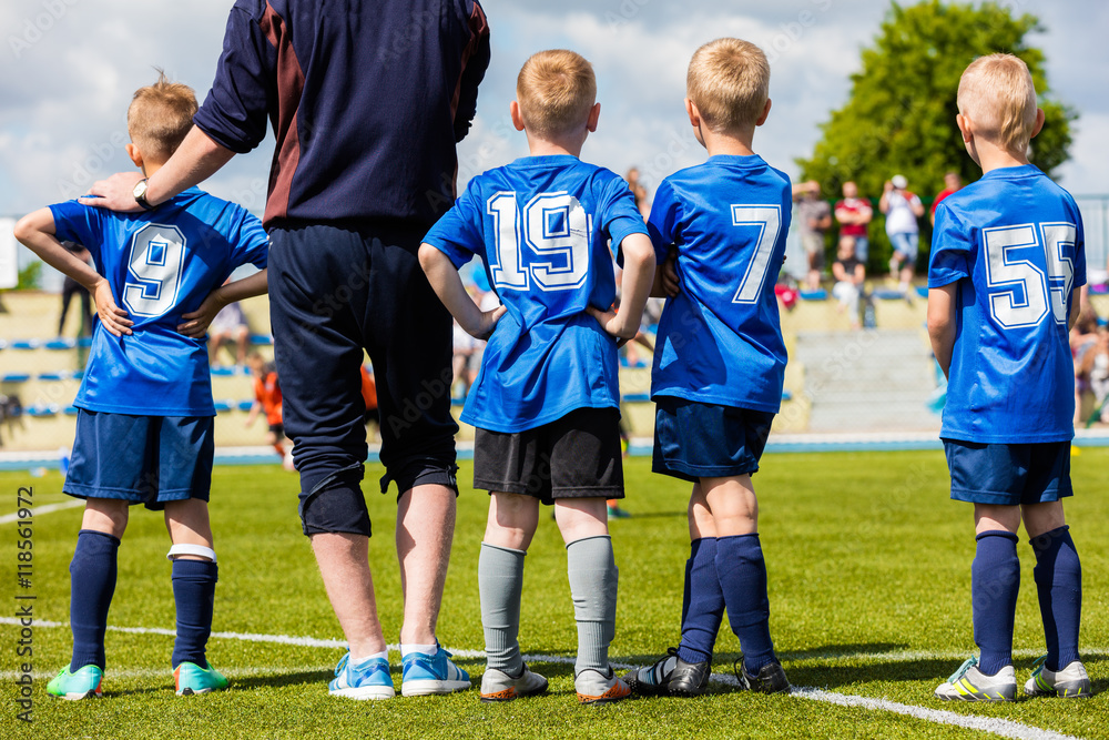 Football soccer match game for children. Youth sports team with soccer coach during football match at the stadium.