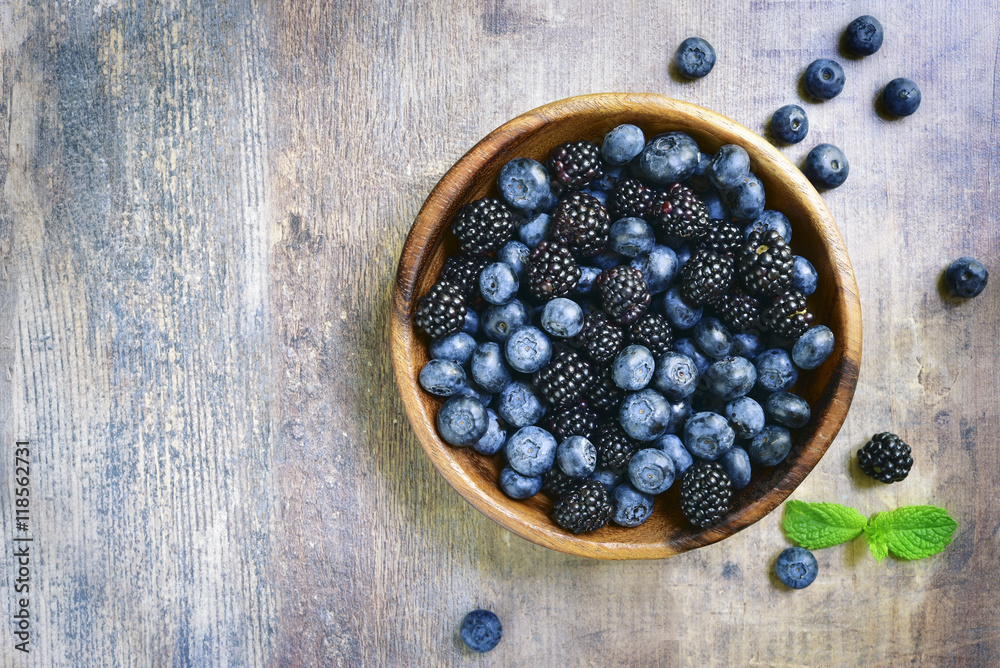 Forest berries (blueberry,bramble) in a wooden bowl.Top view. Forest berries (blueberry,bramble) in a wooden bowl.Top view.