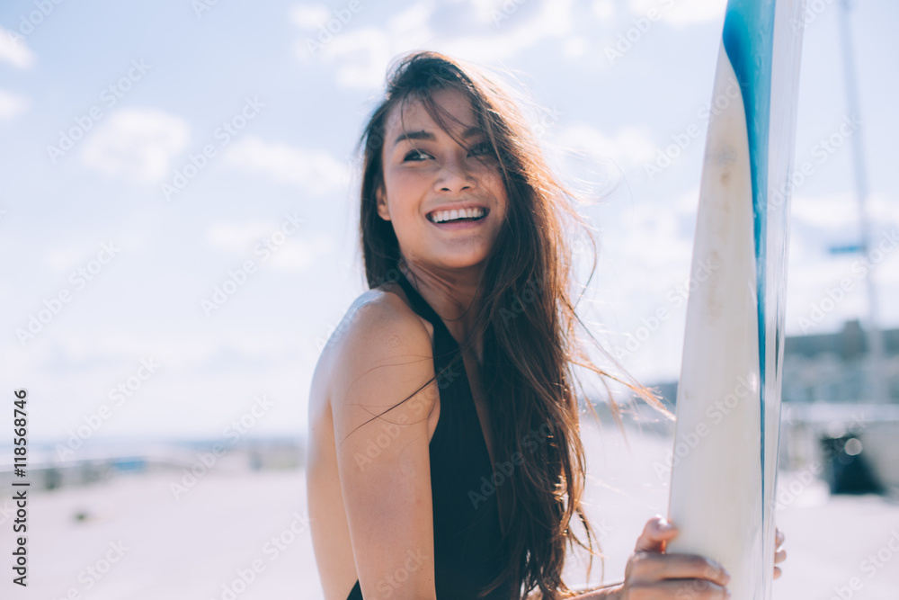 Fototapeta premium A beautiful tan girl is ready to surfing