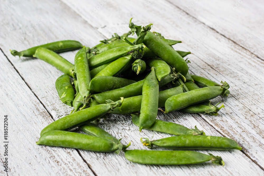 green peas pods on a white wooden table green peas pods on a white wooden table
