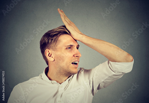 silly man, slapping hand on head having duh moment regrets photo