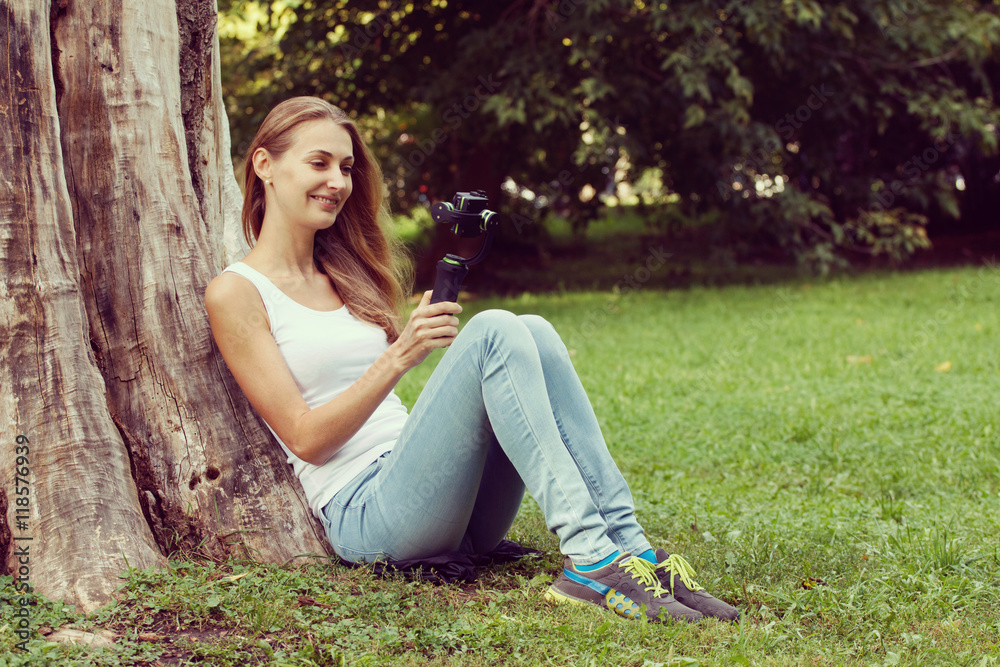 Young woman sitting on the grass and reading book outdoor. Vintage filtered image Young woman sitting on the grass and reading book outdoor. Vintage filtered image