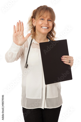 A good looking female doctor wearing a white shirt and black pants, holding a clipboard with a stethoscope around her neck. White background.