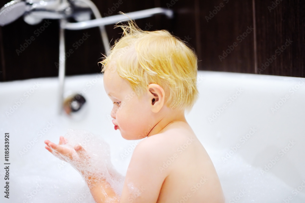 Blond toddler boy taking a bath playing with foam Blond toddler boy taking a bath playing with foam