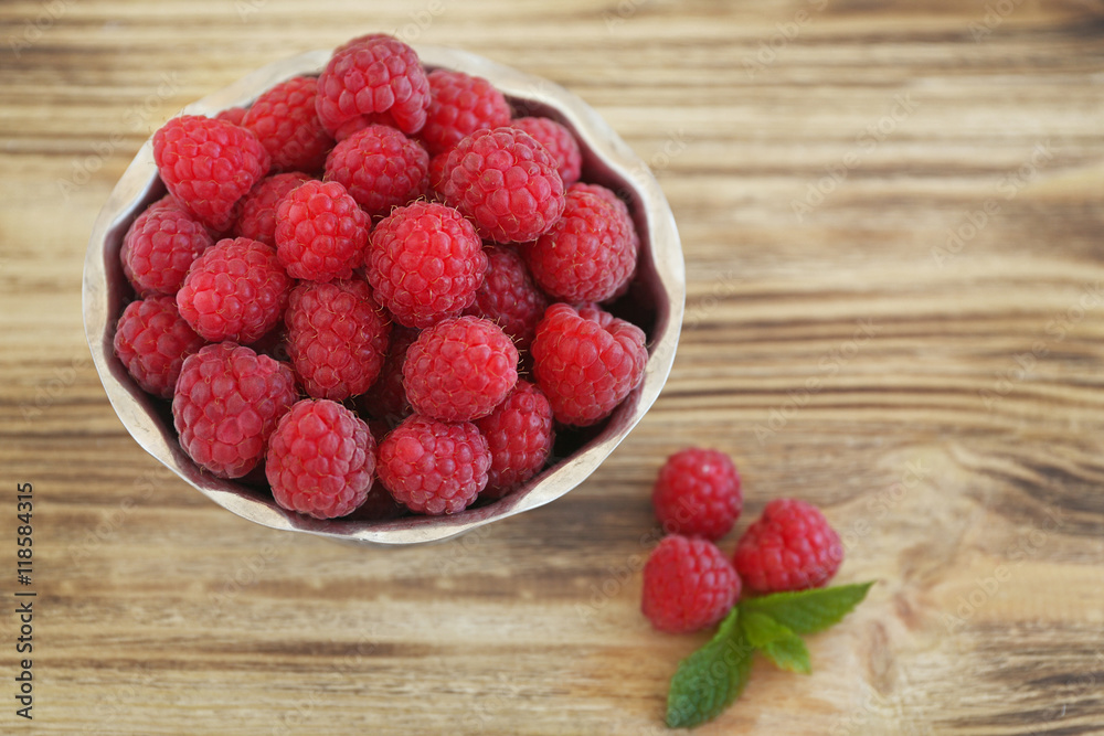 Fresh raspberry in bowl on wooden table Fresh raspberry in bowl on wooden table