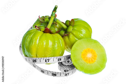 Garcinia cambogia fresh fruit with tapeline, isolated on white. photo