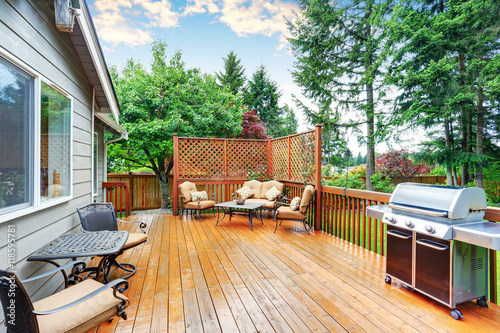 Spacious wooden deck with patio area and attached pergola.