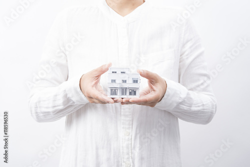 白い住宅模型を持つ女性 