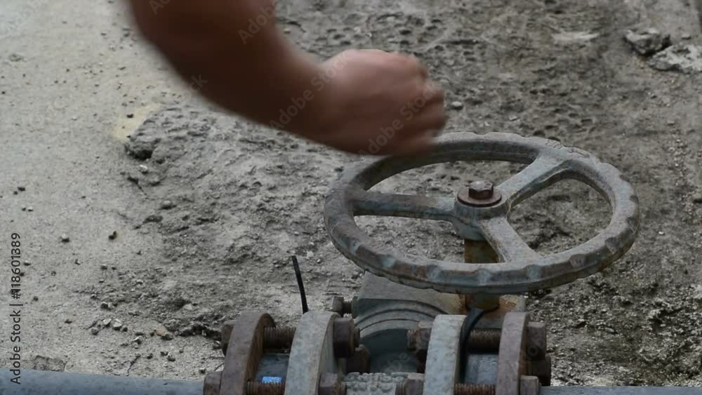 Open valve for water pipe. Complex for water treatment tank with waste water with aeration process. Worker outdoors Open valve for water pipe. Complex for water treatment tank with waste water with aeration process. Worker outdoors