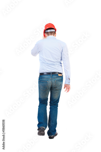 Back view of walking engineer in helmet. Rear view people collection. Backside view of person. Isolated over white background. Bearded businessman in a white shirt and holding a helmet run helmet.