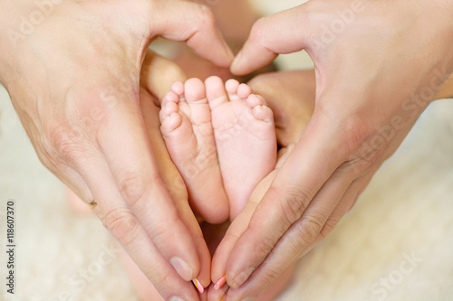 baby feet in mom's and dad's hands with a blurred background