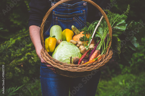 Woman farmer holding a basket of vegetables