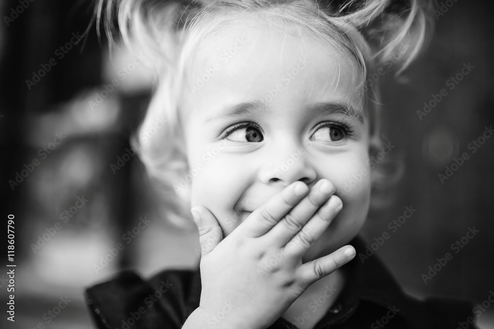 Black and white picture of pretty girl hiding her smile behind t Black and white picture of pretty girl hiding her smile behind t