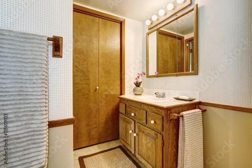 Bathroom interior with vanity cabinet, tile floor and rug