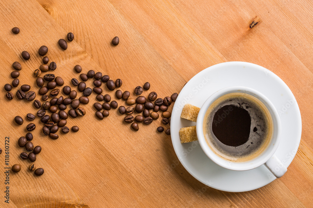 Coffee cup, sugar and coffee beans on wooden background.