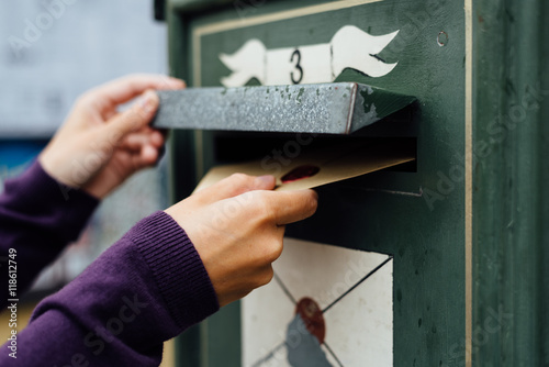 Fotografie, Obraz Posting letter to old postbox on street