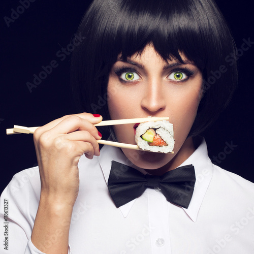 Young woman eating sushi with big green eyes