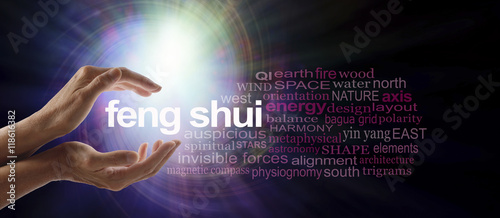 Shedding light on Feng Shui - Female hands cupped around the words FENG SHUI surrounded by a relevant word cloud with a spiraling bright light vortex behind photo