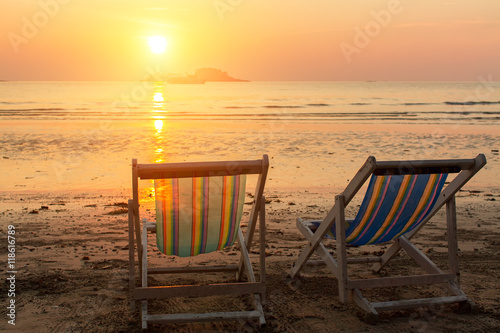 Pair of beach loungers on the sea sunset.