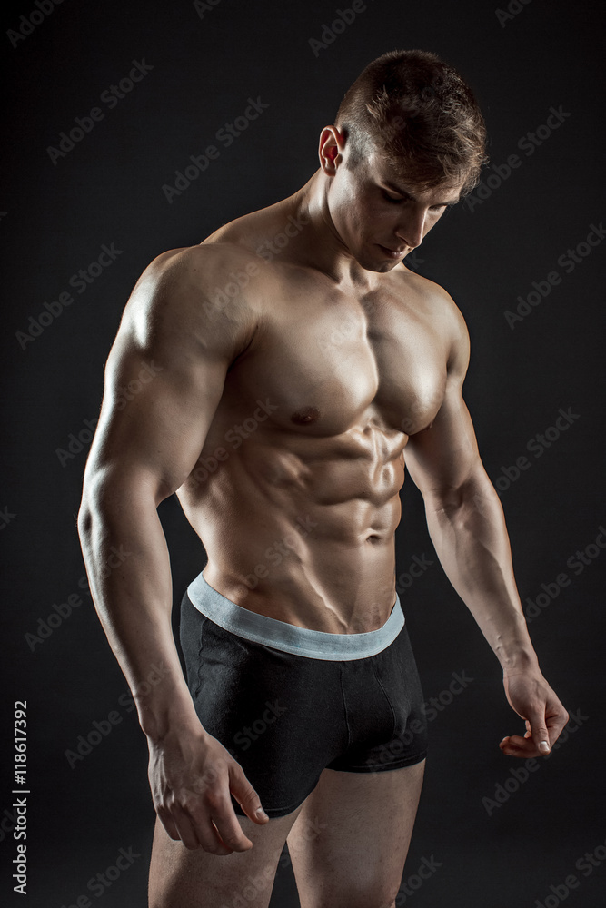 Muscular bodybuilder guy doing posing over black background Muscular bodybuilder guy doing posing over black background