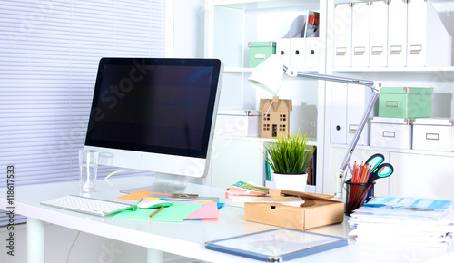 Designer working desk with computer and paperwork