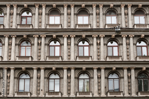 Detail of the facade of a multistory building in classical style with columns and windows.