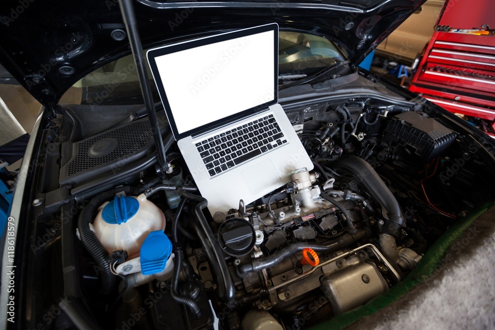Cars with laptop on open hood for servicing Cars with laptop on open hood for servicing