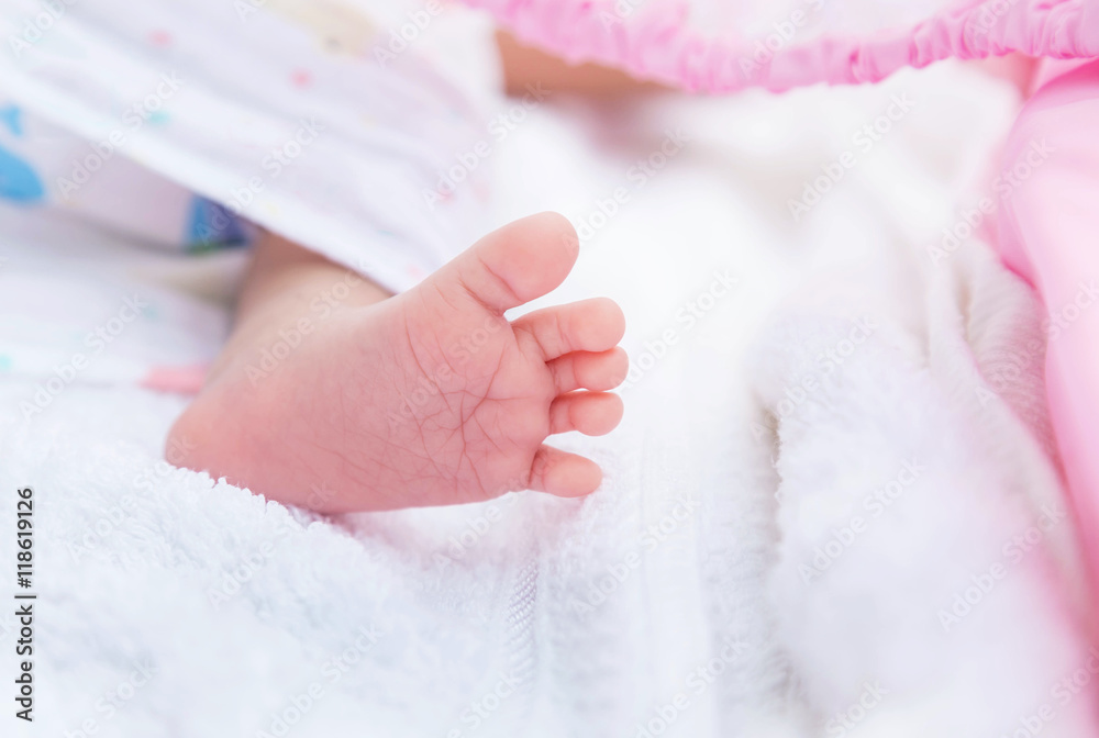 Close up little feet of baby newborn covered in white towel selective focus Close up little feet of baby newborn covered in white towel selective focus
