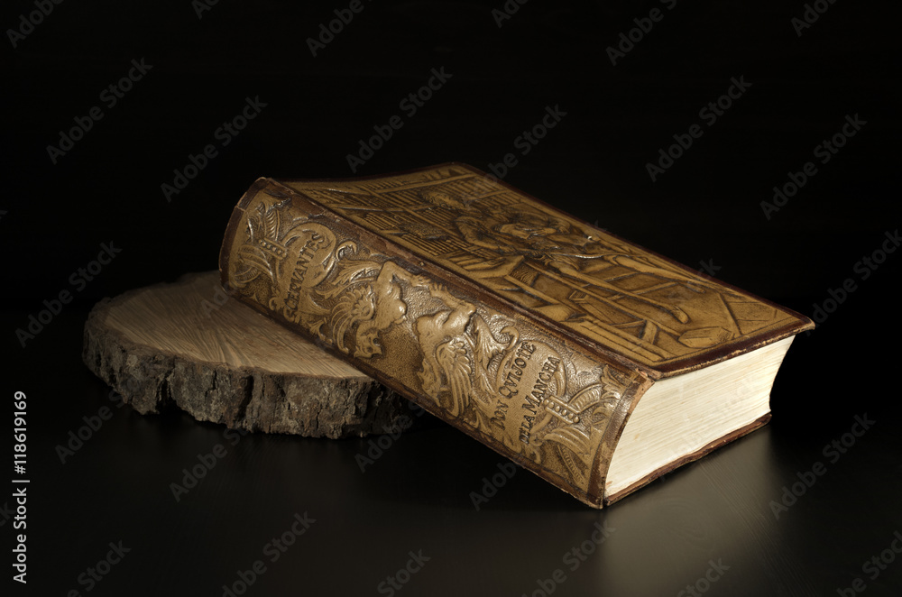 Fototapeta premium Miguel de Cervantes - Detail Old Embossed Leather Book Edition of The Ingenious Gentleman Don Quixote of La Mancha, Isolated on Dark Background