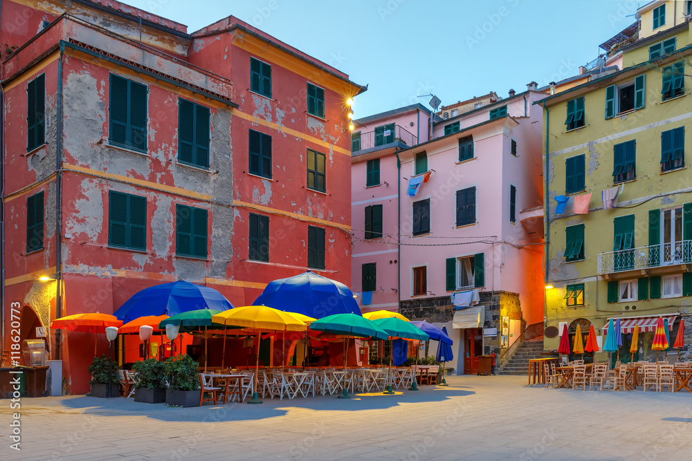 Night fishing village Vernazza with colorful umbrellas and tables on town square, Five lands, Cinque Terre National Park, Liguria, Italy.