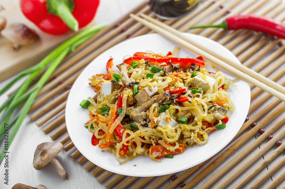 Asian food. Fried rice noodles with tofu, vegetables and shiitake mushroom. Oriental cuisine meal. Asian food. Fried rice noodles with tofu, vegetables and shiitake mushroom. Oriental cuisine meal.
