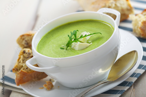 Traditional cream soup made of spinach on a table. Classic European food.