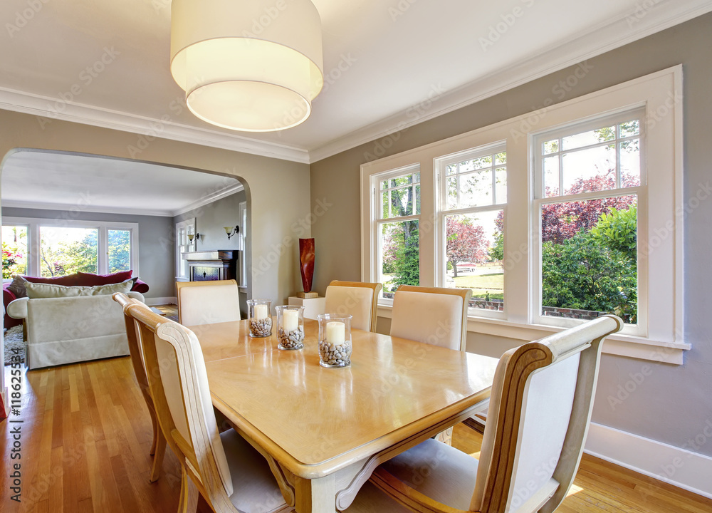 Fototapeta premium Open floor plan dining room with table set and hardwood floor.