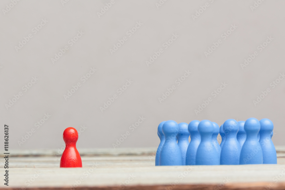 Rote Spielfigur mit Gruppe von bauen Spielfiguren