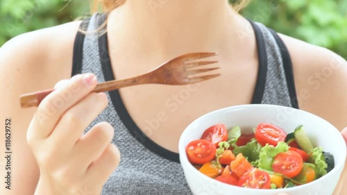 Young girl eating a vegetable salad after a workout . Fitness and healthy lifestyle concept.